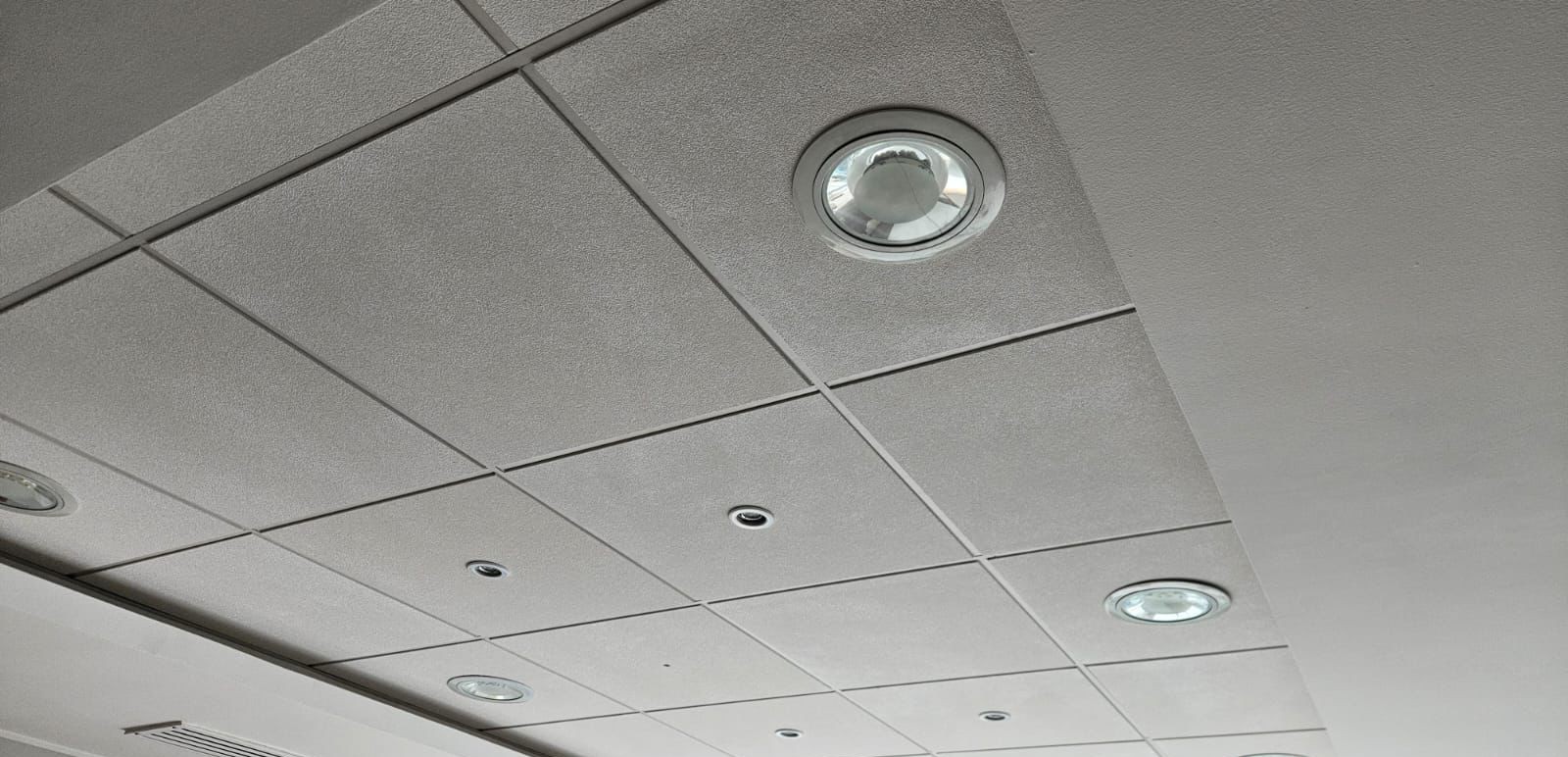 Cielo americano de fibra mineral con focos LED empotrados en un local comercial