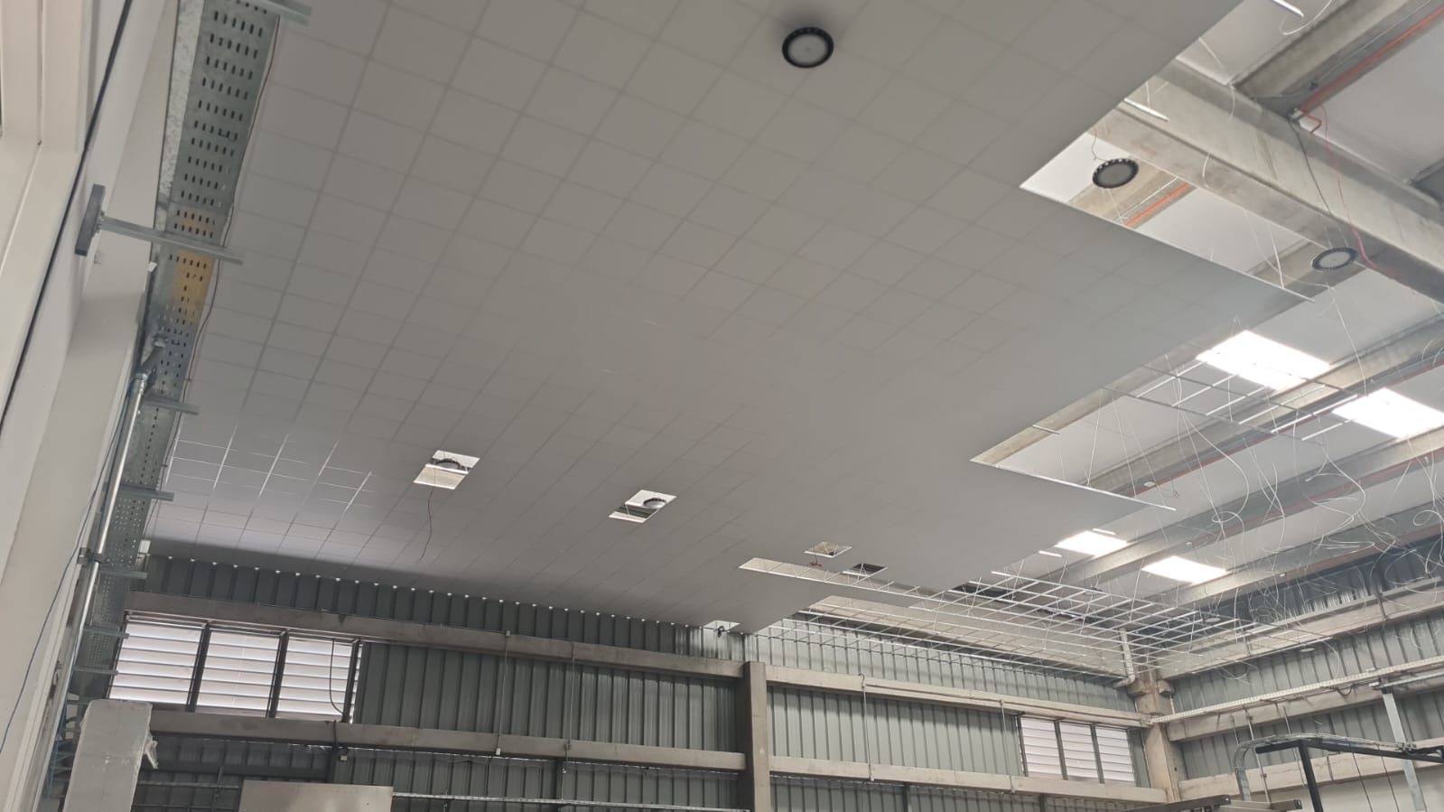 Cielo modular montado bajo la estructura metálica de un galpón