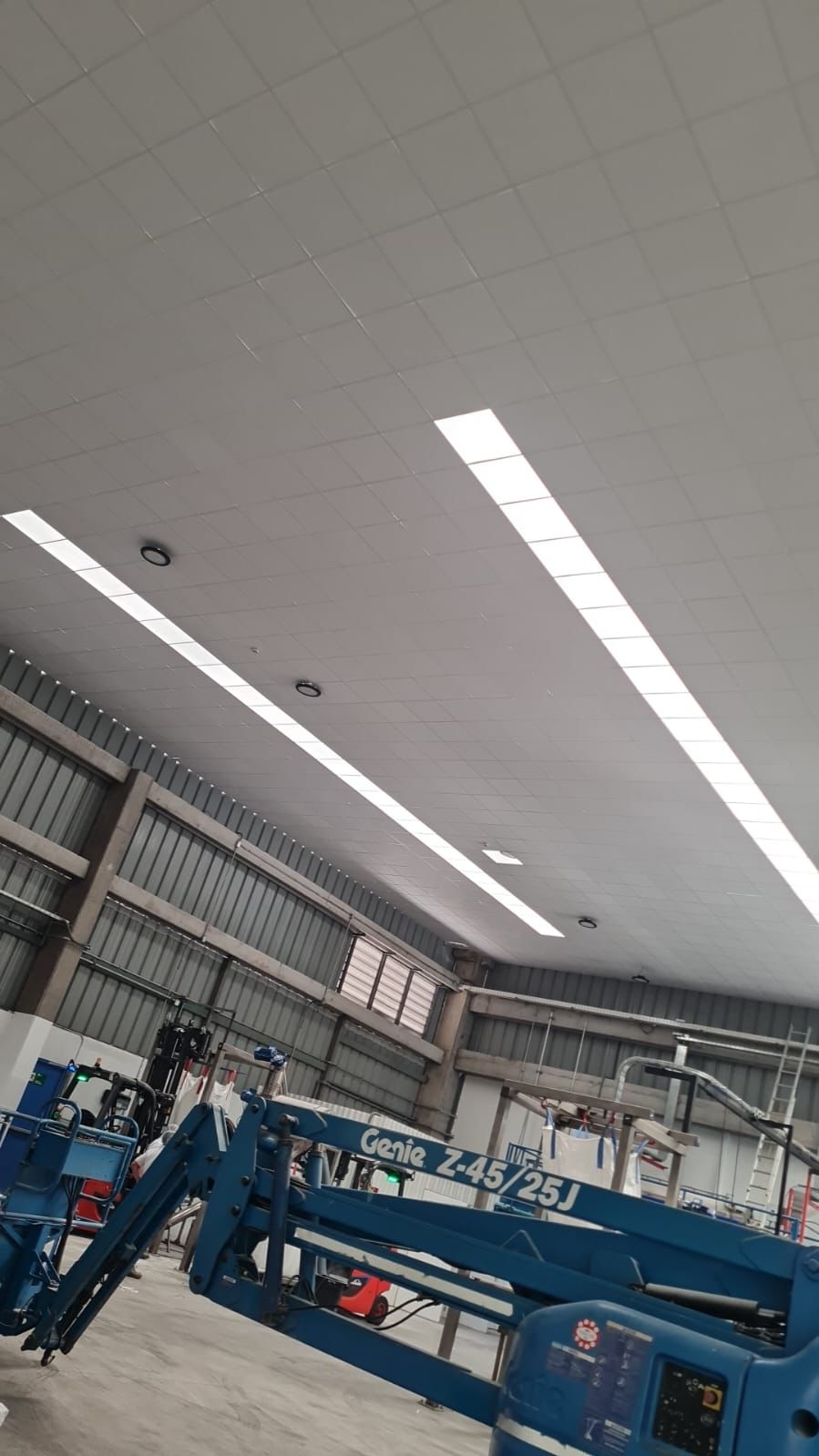 Luminaria LED lineal empotrada en el cielo modular de una nave