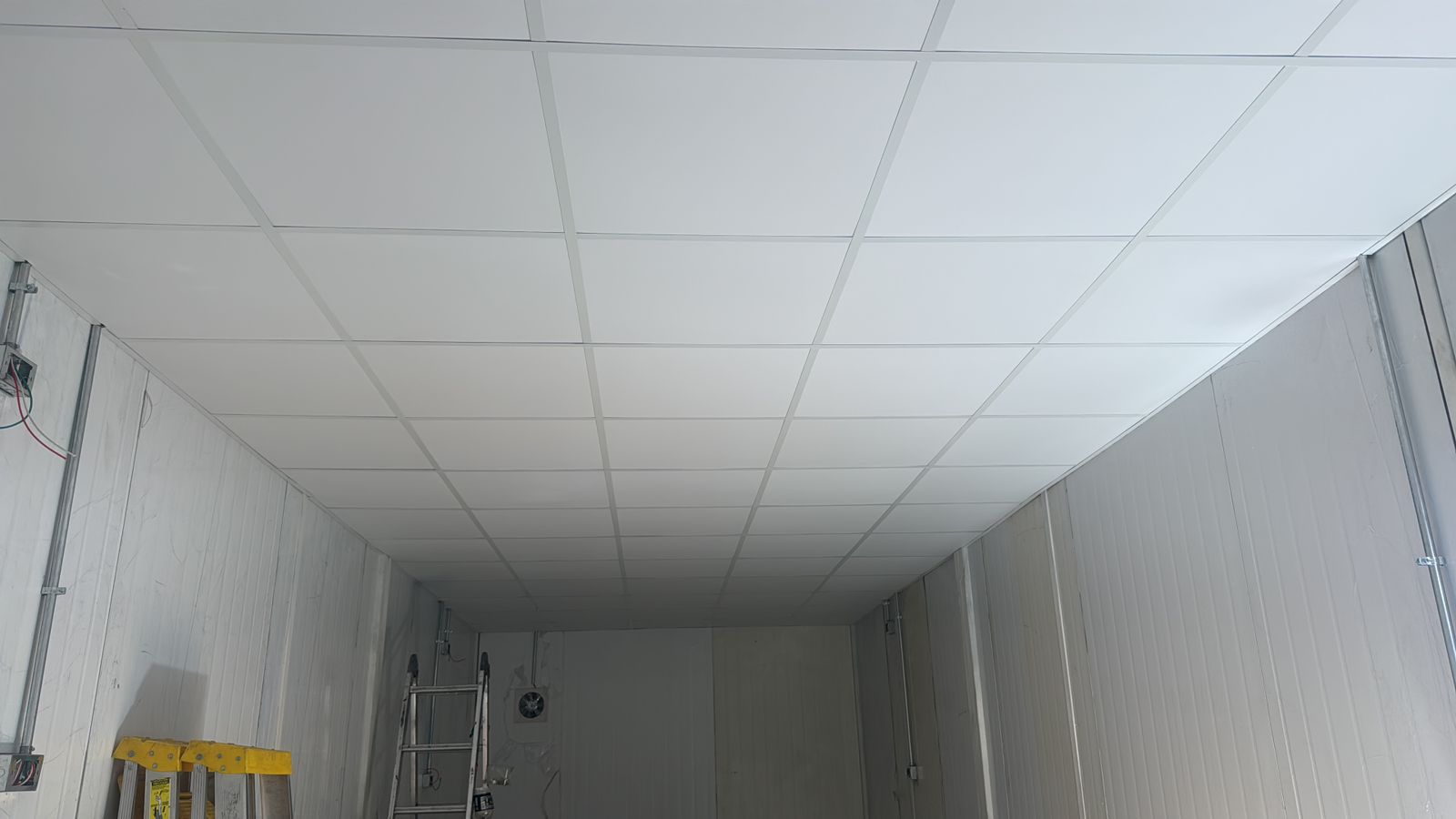 Sala terminada con cielo americano blanco y muros lisos