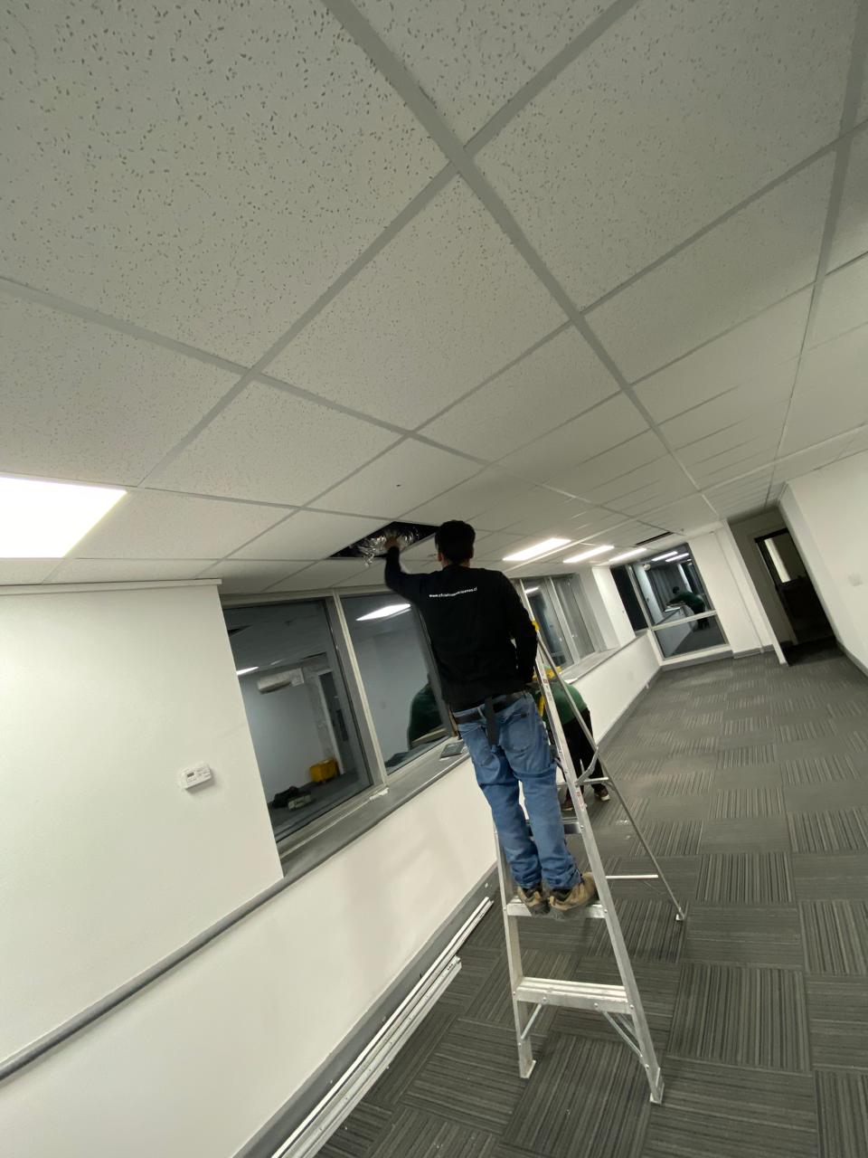 Instalador trabajando en el cielo de un pasillo