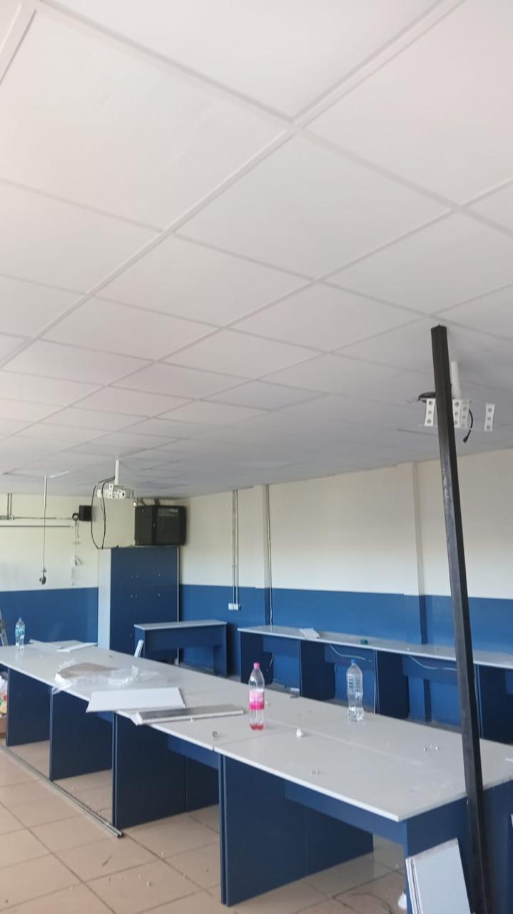 Sala de reuniones con cielo modular y mesas de trabajo