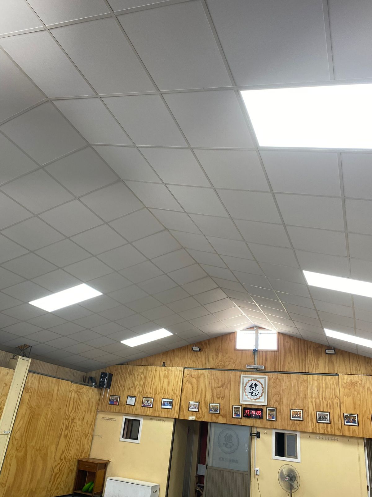Espacio con cielo modular, paneles LED y revestimiento de madera