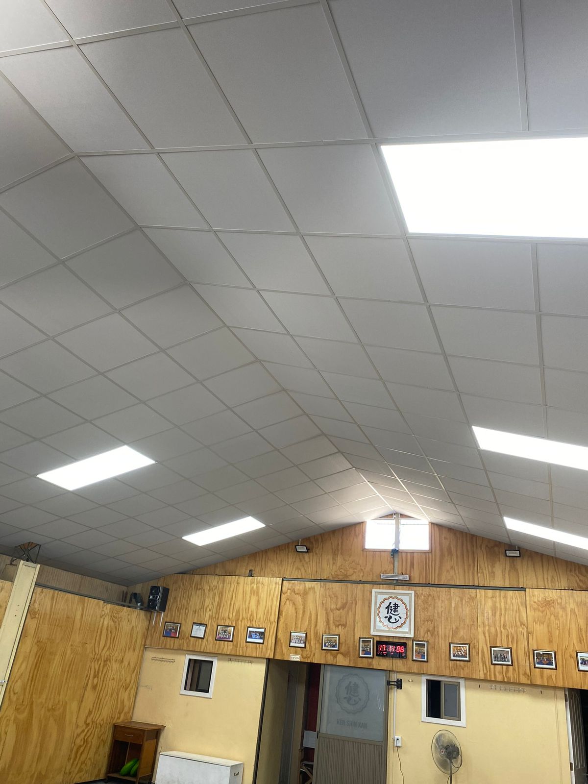 Oficina con cielo americano, paneles LED y revestimiento de madera