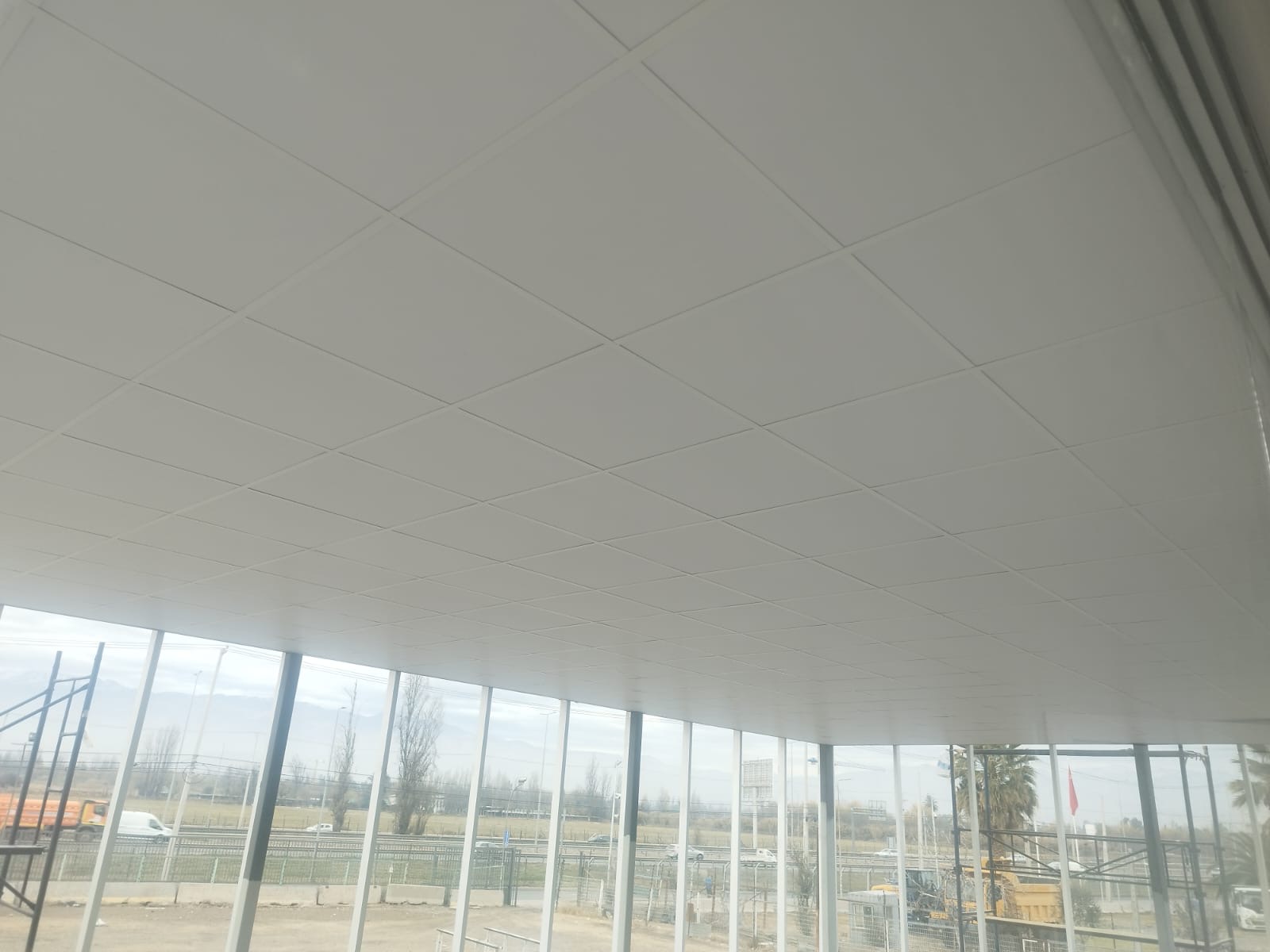 Cielo modular sobre un pasillo con fachada de vidrio