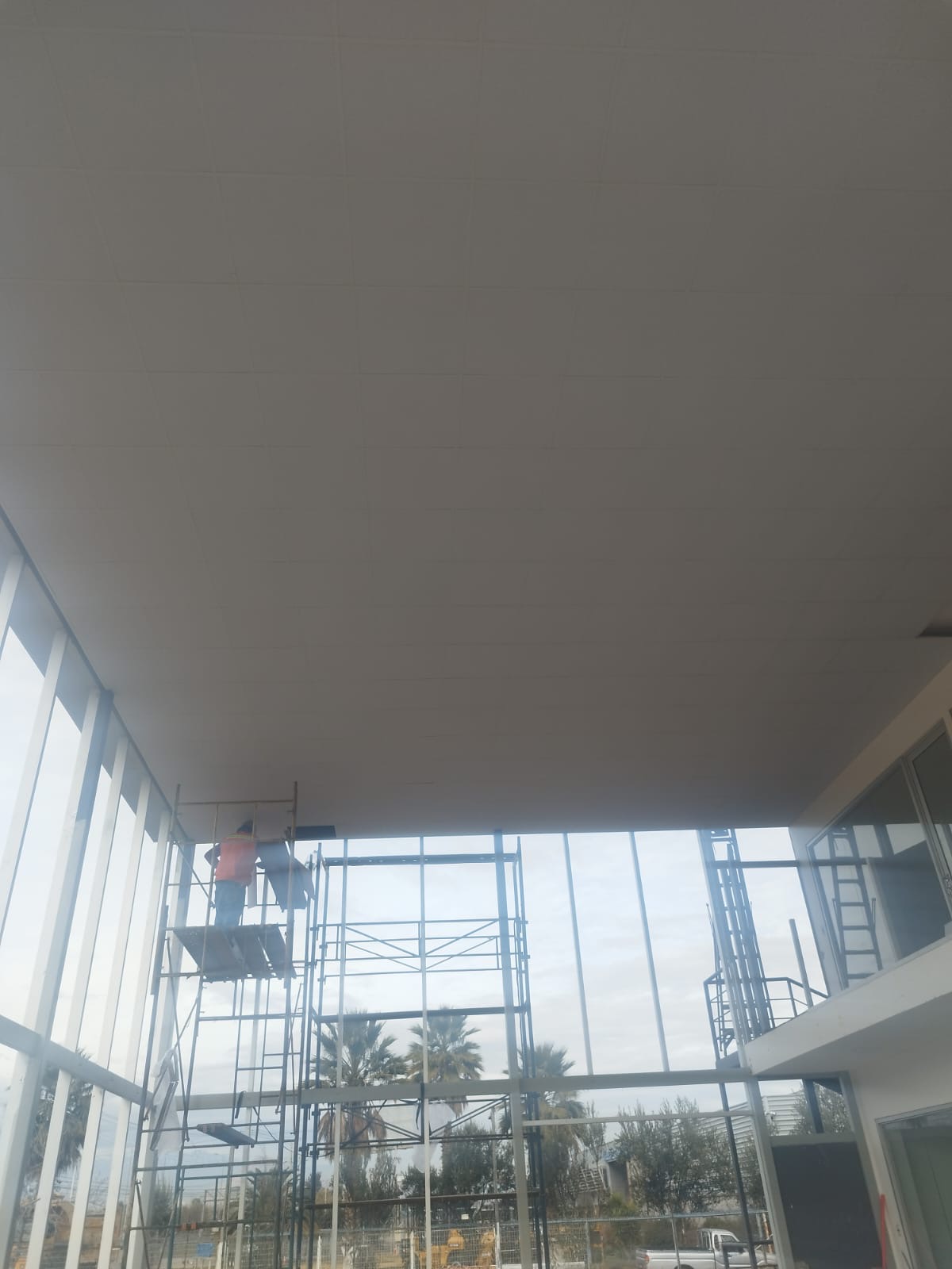 Cielo americano en un hall de doble altura con muro cortina