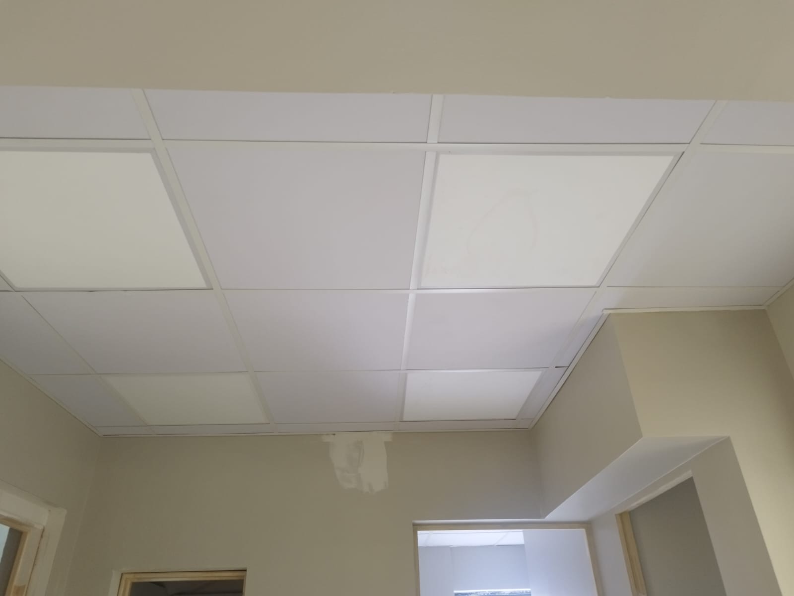 Sala con cielo modular blanco y paneles LED encendidos